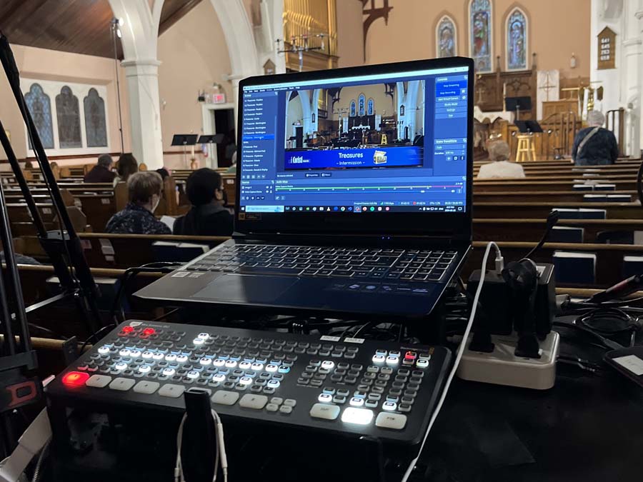 Camera viewfinder showing family at live funeral broadcast